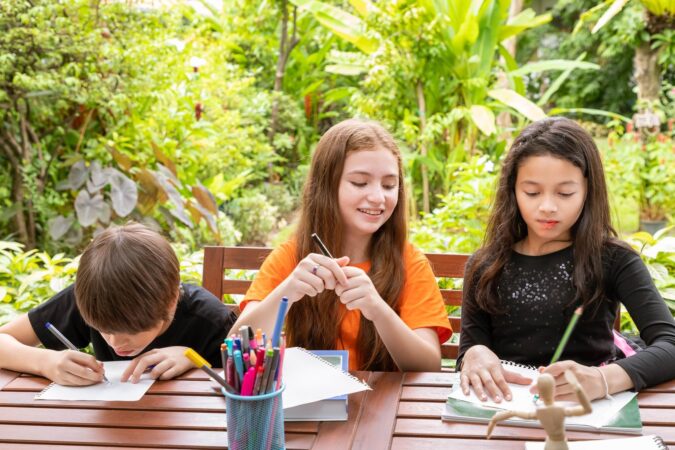 children-boy-girl-doing-homework-drawing-together-garden-home_554837-161